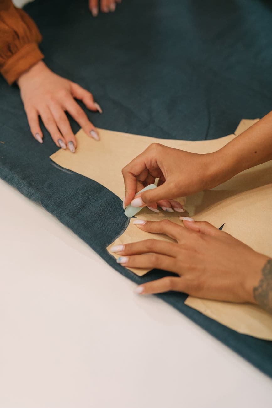 Hands tracing a pattern onto fabric